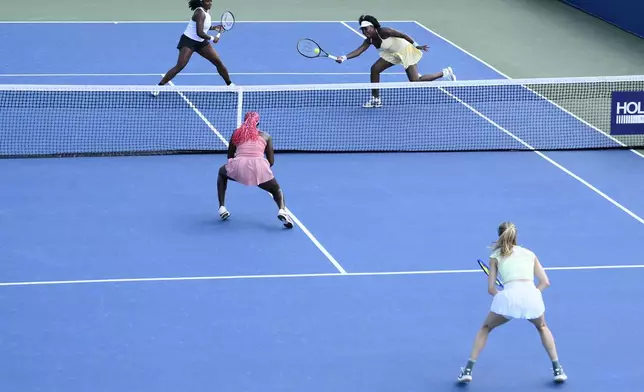 Hailey Baptiste, top left, and Venus Williams top right, compete during a doubles match against Eugenie Bouchard, bottom right, and Clervie Ngounoue, bottom left, at the Citi Open tennis tournament Monday, July 21, 2025, in Washington. (AP Photo/Nick Wass)