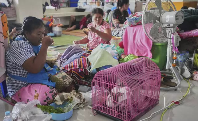 Bualee Chanduang, left, with her rabbit who fled homes following clashes between Thai and Cambodian soldiers at an evacuation center in Surin province,Thailand, Sunday, July 27, 2025. (AP Photo/Sakchai Lalit)