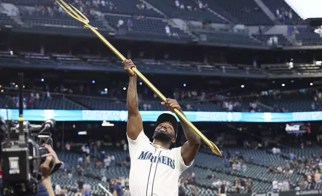 Seattle Mariners' Randy Arozarena hoists the trident after a baseball game against the Kansas City Royals, Monday, June 30, 2025, in Seattle. (AP Photo/John Froschauer)