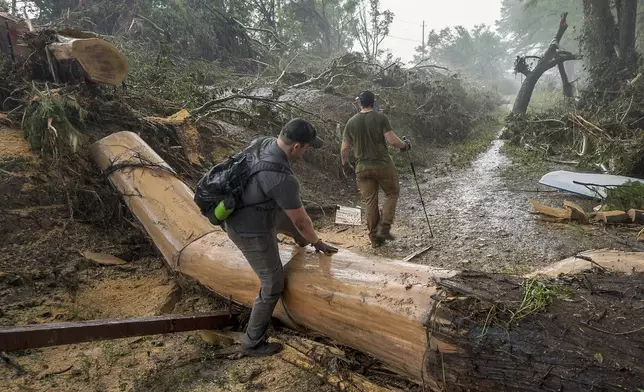 Volunteers search for missing people along the banks of the Guadalupe River after recent flooding on Sunday, July 6, 2025, in Hunt, Texas. (AP Photo/Rodolfo Gonzalez)
