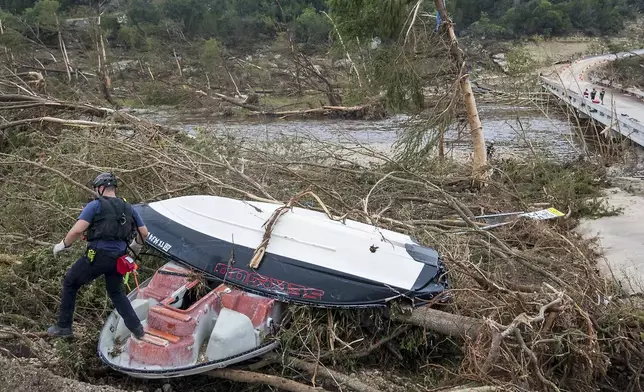 First responders from College Station Fire Department search along the banks of the Guadalupe River, as rescue efforts continue following extreme flooding, Sunday, July 6, 2025, in Ingram, Texas. (AP Photo/Rodolfo Gonzalez)