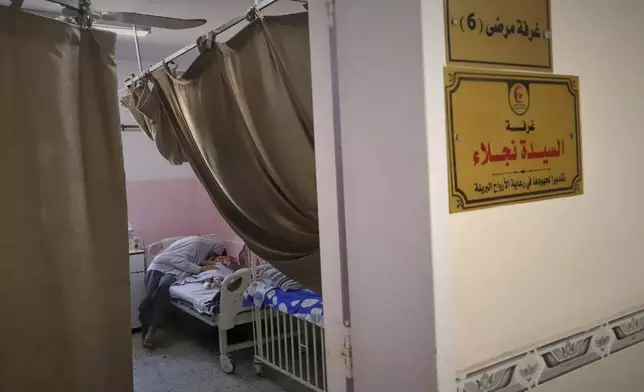 Nour al-Hams cares for her 3-year-old nephew, Amr al-Hams, who lies in a hospital bed with brain damage caused by an Israeli strike on his family's tent in April, at Nasser Hospital in Khan Younis, Gaza Strip, Wednesday, June 25, 2025. (AP Photo/Mariam Dagga)