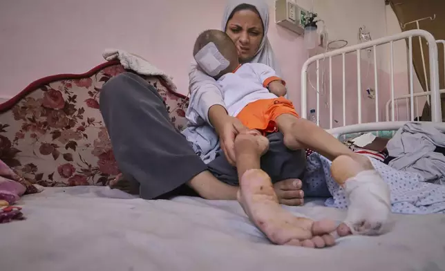 Nour al-Hams cares for her 3-year-old nephew, Amr al-Hams, who lies in a hospital bed with brain damage caused by an Israeli strike on his family's tent in April, at Nasser Hospital in Khan Younis, Gaza Strip, Wednesday, June 25, 2025. (AP Photo/Mariam Dagga)