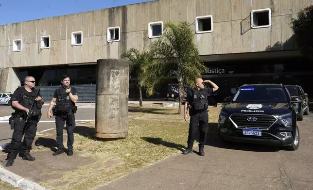 Federal police stand outside the Secretariat of Penitentiary Administration office where Brazil's former President Jair Bolsonaro arrived after the Supreme Court ordered him to be fitted with an electronic ankle monitor, in Brasilia, Brazil, Friday, July 18, 2025. (AP Photo/Eraldo Peres)