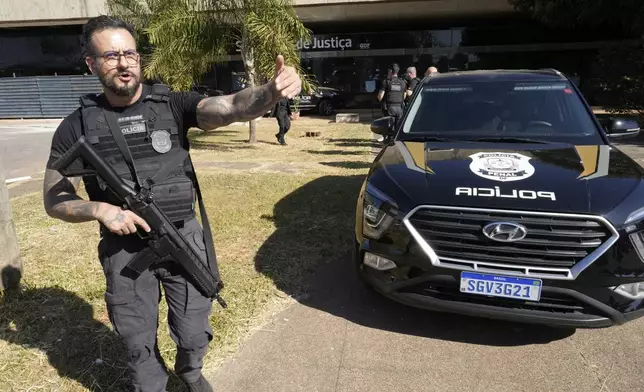 Federal police stand outside the Secretariat of Penitentiary Administration office where Brazil's former President Jair Bolsonaro arrived after the Supreme Court ordered him to be fitted with an electronic ankle monitor, in Brasilia, Brazil, Friday, July 18, 2025. (AP Photo/Eraldo Peres)