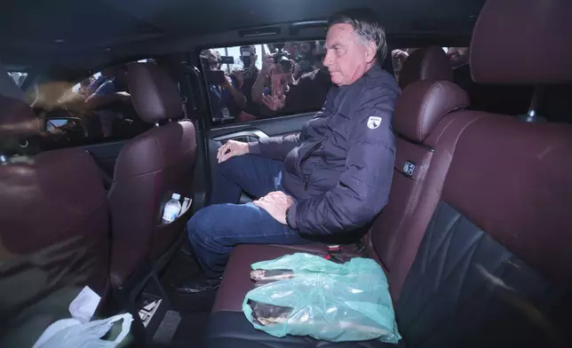 Brazil's former President Jair Bolsonaro leaves the Secretariat of Penitentiary Administration where he arrived after the Supreme Court ordered him to be fitted with an electronic ankle monitor in Brasilia, Brazil, Friday, July 18, 2025. (AP Photo/Luis Nova)