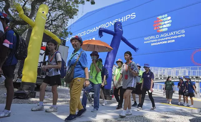 Visitors arrive at the venue for the World Aquatics 2025 in Singapore, Wednesday, July 23, 2025. (AP Photo/Ng Han Guan)
