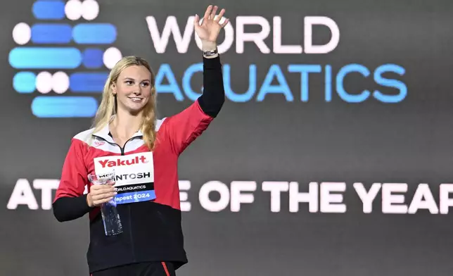 FILE - Canada's Summer Mcintosh holds a trophy for the Athlete of the Year at the World Short Course Swimming Championships in Budapest, Hungary, on Dec. 15, 2024. (AP Photo/Denes Erdos, File)