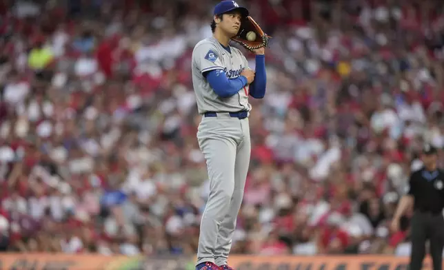 Los Angeles Dodgers' Shohei Ohtani pauses during the fourth inning of a baseball game against the Cincinnati Reds Wednesday, July 30, 2025, in Cincinnati. (AP Photo/Carolyn Kaster)