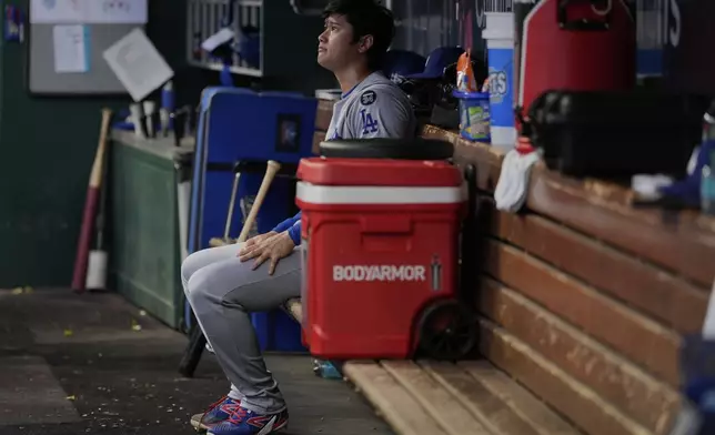 Los Angeles Dodgers' Shohei Ohtani sits in the dugout after being relieved during the fourth inning of a baseball game against the Cincinnati Reds Wednesday, July 30, 2025, in Cincinnati. (AP Photo/Carolyn Kaster)