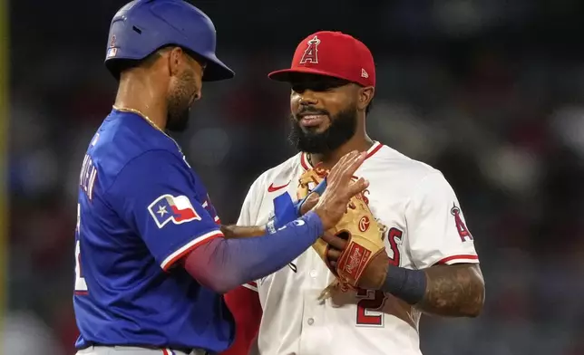 Texas Rangers' Marcus Semien, left, and Los Angeles Angels second baseman Luis Rengifo chat during the sixth inning of a baseball game Wednesday, July 30, 2025, in Anaheim, Calif. (AP Photo/Mark J. Terrill)