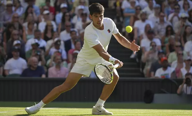 Carlos Alcaraz of Spain returns to Fabio Fognini of Italy during their first round men's singles match at the Wimbledon Tennis Championships in London, Monday, June 30, 2025. (AP Photo/Alastair Grant)
