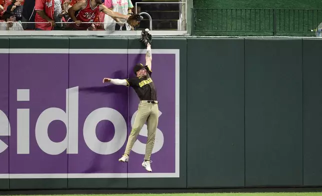 San Diego Padres center fielder Jackson Merrill leaps in vain for a home run hit by Washington Nationals' Nathaniel Lowe during the sixth inning of a baseball game, Saturday, July 19, 2025, in Washington. (AP Photo/Nick Wass)