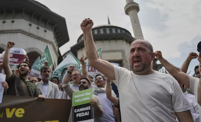 People shout slogans during a protest against satirical LeMan magazine after they published a cartoon that allegedly depicted the Prophet Muhammad, outside Taksim mosque, in Istanbul, Turkey, Tuesday, July 1, 2025. Boards read in Turkish: "You will drown in the filth of shameless Leman", "I sacrifice my life to Prophet Muhammad". (AP Photo/Francisco Seco)