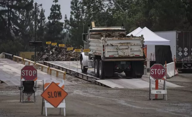 A dump truck carrying debris removed from January wildfires arrives at a recycling facility set up on a golf course in Altadena, Calif., Wednesday, June 4, 2025. (AP Photo/Jae C. Hong)