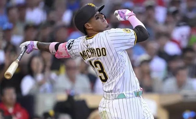 San Diego Padres' Manny Machado hits a sacrifice fly to score Fernando Tatis Jr. during the seventh inning of a baseball game against the Philadelphia Phillies, Saturday, July 12, 2025, in San Diego. (AP Photo/Orlando Ramirez)