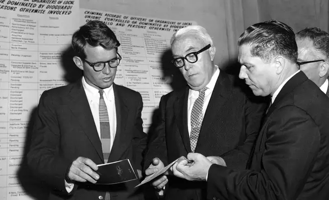 FILE - Robert Kennedy, left, counsel for the Senate Rackets Investigating Committee, attorney George S. Fitzgerald, center, and his client, Teamster Union Vice President James R. Hoffa, confer during a break in hearings in Washington, D.C., in Sept. 1957. (AP Photo, File)