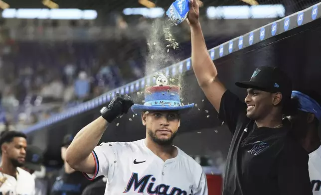 Miami Marlins' Agustin Ramirez, left, celebrates in the dugout after hitting a two-run home run during the first inning of a baseball game against the Minnesota Twins, Thursday, July 3, 2025, in Miami. (AP Photo/Lynne Sladky)