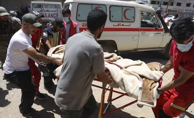Red Crescent volunteers carry a government soldier injured in Sweida city during clashes between the government forces and Druze militias at a clinic in Busra al-Harir village, southern Syria, Tuesday, July 15, 2025. (AP Photo/Omar Albam)