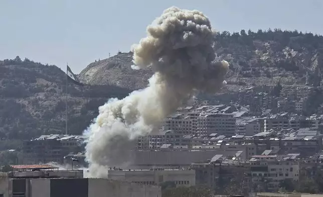 In this photo released by the Syrian official news agency SANA, smoke rises from an Israeli airstrike that hit the Syrian Defence Ministry, in Damascus, Syria, Wednesday, July 16, 2025. (SANA via AP)