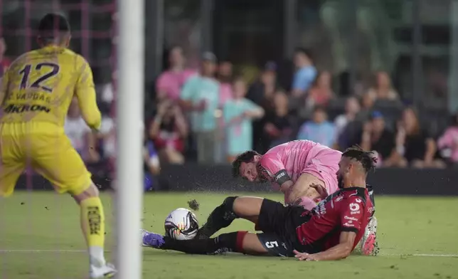 Inter Miami forward Lionel Messi, back, attempts to score past Atlas defender Doria (5) and goalkeeper Camilo Vargas (12) during the first half of a Leagues Cup group stage soccer match, Wednesday, July 30, 2025, in Fort Lauderdale, Fla. (AP Photo/Rebecca Blackwell)
