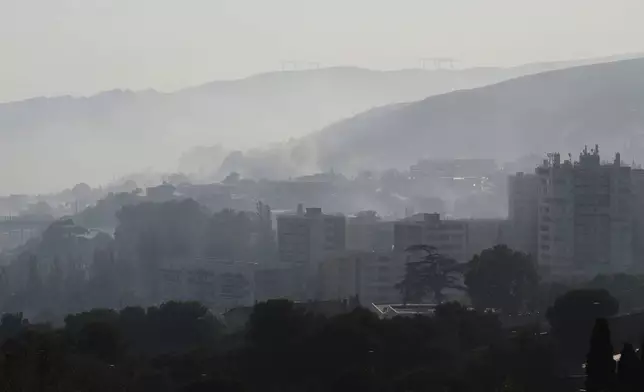 CORRECTS TO CASTELLANE, NOT CATELLANE - Smoke rises behind buildings during wildfire Tuesday, July 8, 2025 in La Castellane district of Marseille, southern France. (AP Photo/Lewis Joly)