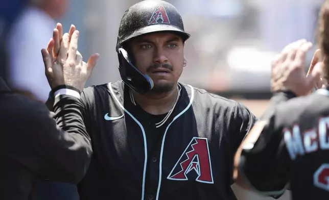 Arizona Diamondbacks' Josh Naylor celebrates in the dugout with his teammates after scoring during the fourth inning of a baseball game against the Los Angeles Angels in Anaheim, Calif., Sunday, July 13, 2025. (AP Photo/Jessie Alcheh)