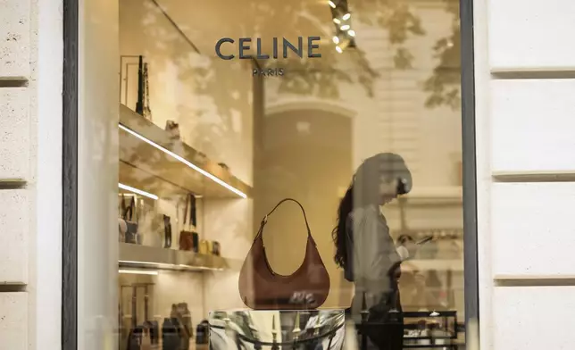 A woman works in a Celine shop, Monday, July 28, 2025 in Paris. (AP Photo/Thomas Padilla)