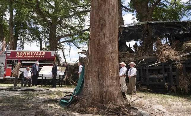 First lady Melania Trump, from left, Texas Gov. Greg Abbott and President Donald Trump are briefed on flood damage in Kerrville, Texas, Friday, July 11, 2025. (AP Photo/Jacquelyn Martin)