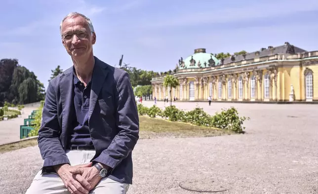 Jürgen Luh, historian of the Prussian Palaces and Gardens Foundation, poses for a portrait in front of King Frederick II of Prussia summer home Sanssouci Palace, in Potsdam, Germany, June 17, 2025. (AP Photo/Markus Schreiber)