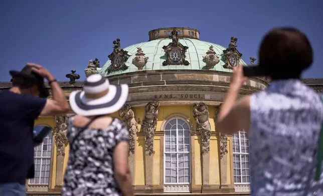 Visitors takes photos of Sanssouci Palace, the summer home of King Frederick II of Prussia, in Potsdam, Germany, June 17, 2025. (AP Photo/Markus Schreiber)