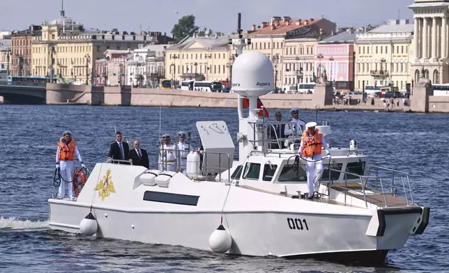 Russian President Vladimir Putin, third from left, stands aboard the Raptor boat during his visit to St. Petersburg on Navy Day, Russia, on Sunday, July 27, 2025. (Alexei Danichev, Sputnik, Kremlin Pool Photo via AP)