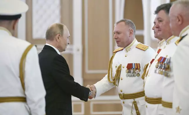 Russian President Vladimir Putin, left, shakes hands with Russian Navy officers during his visit to St. Petersburg on Navy Day, Russia, on Sunday, July 27, 2025. (Alexei Danichev, Sputnik, Kremlin Pool Photo via AP)