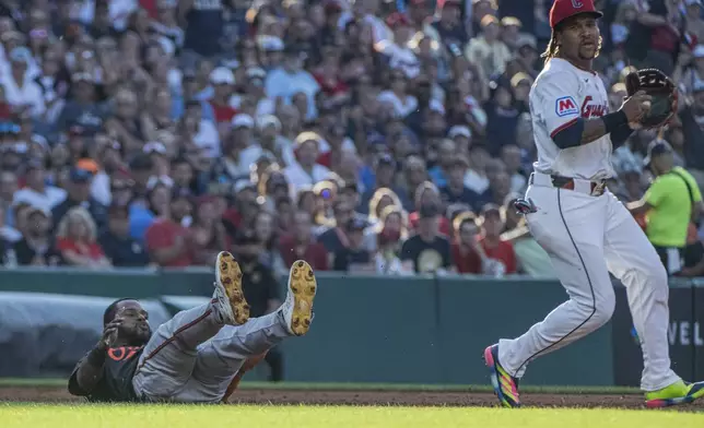 Baltimore Orioles' Cedric Mullins, left, falls down after being tagged out in a rundown by Cleveland Guardians' Jose Ramirez during the third inning of a baseball game, Wednesday, July 23, 2025, in Cleveland. (AP Photo/Phil Long)