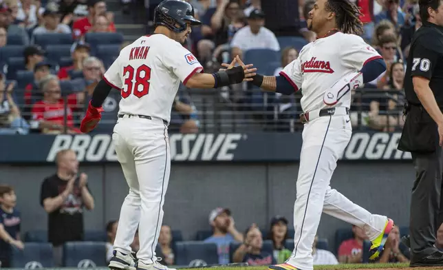 Cleveland Guardians' Steven Kwan (38) congratulates Jose Ramirez, right, after they scored on a single by Kyle Manzardo during the fourth inning of a baseball game against the Baltimore Orioles, Wednesday, July 23, 2025, in Cleveland. (AP Photo/Phil Long)