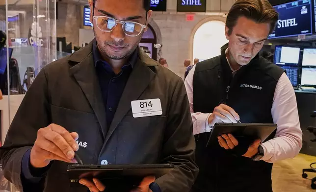Trader Niall Pawa, left, works with a colleague on the floor of the New York Stock Exchange, Tuesday, July 1, 2025. (AP Photo/Richard Drew)