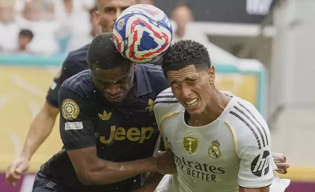 Juventus' Pierre Kalulu, left, and Real Madrid's Jude Bellingham go for the ball during the Club World Cup round of 16 soccer match between Real Madrid and Juventus in Miami Gardens, Fla., Tuesday, July 1, 2025. (AP Photo/Rebecca Blackwell)