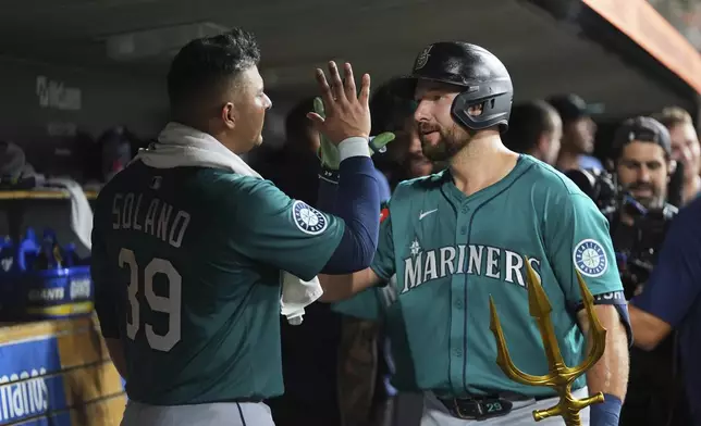 Seattle Mariners' Cal Raleigh right, celebrates his grand slam with Donovan Solano (39) against the Detroit Tigers in the ninth inning during a baseball game, Friday, July 11, 2025, in Detroit. (AP Photo/Paul Sancya)