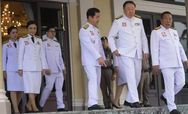 Thailand's acting Prime Minister Suriya Jungrungruangkit, fourth, from left leaves Government House with his new cabinet to take new cabinet oath in front of Thailand's King Maha Vajiralongkorn and Queen Suthida in Bangkok, Thailand, Thursday, July 3, 2025. (AP Photo/Sakchai Lalit)