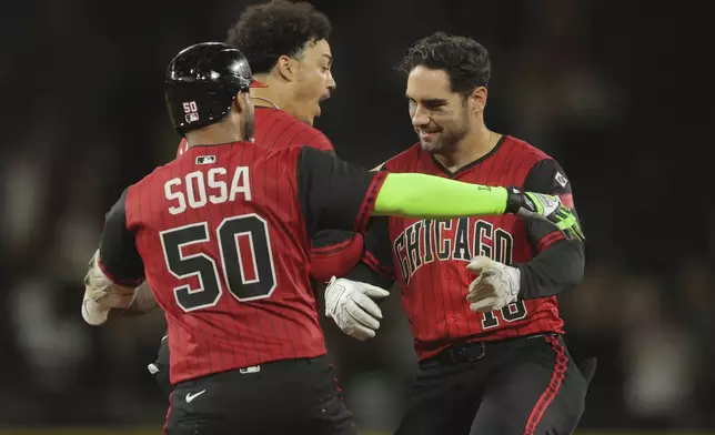 Chicago White Sox's Mike Tauchman, right, celebrates with Miguel Vargas, middle, and Lenyn Sosa (50) after Tauchman's game-winning hit in the 11th inning in the second baseball game of a doubleheader against the Cleveland Guardians, Friday, July 11, 2025, in Chicago. (AP Photo/Melissa Tamez)