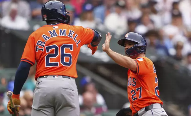 Houston Astros' Taylor Trammell (26) greets Jose Altuve (27) after Altuve scored on an RBI sacrifice fly from Yainer Diaz against the Seattle Mariners during the seventh inning of a baseball game Sunday, July 20, 2025, in Seattle. (AP Photo/Lindsey Wasson)