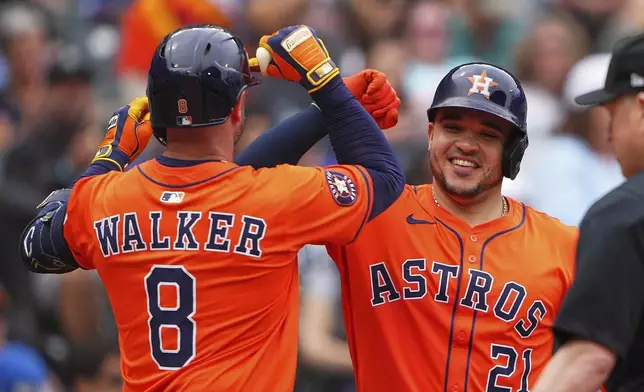 Houston Astros' Christian Walker (8) celebrates his solo home run with Yainer Diaz (21) against the Seattle Mariners during the sixth inning of a baseball game Sunday, July 20, 2025, in Seattle. (AP Photo/Lindsey Wasson)