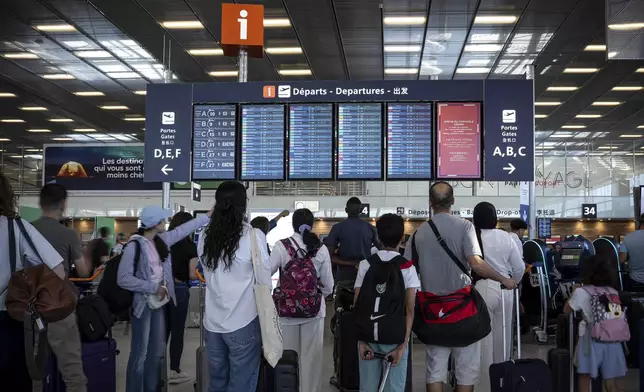 Passengers look a departures information board at Orly airport, near Paris, as French air traffic controllers launched a two-day strike to demand better working conditions, Friday, July 4, 2025. (AP Photo/Aurelien Morissard)