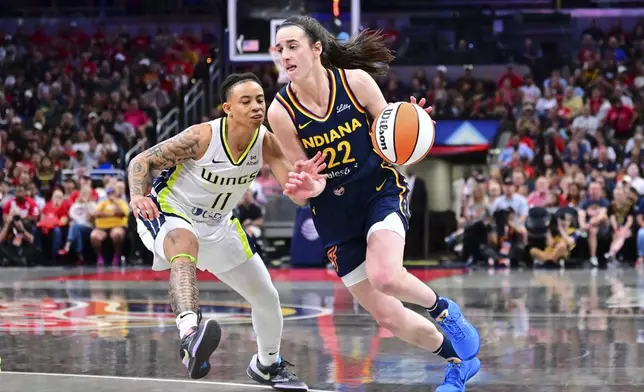 Indiana Fever's Caitlin Clark (22) goes to the basket against Dallas Wings' JJ Quinerly (11) during the second half of a WNBA basketball game, Sunday, July 13, 2025, in Indianapolis. (AP Photo/Doug McSchooler)