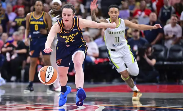 Indiana Fever's Caitlin Clark goes for a loose ball during the first half of a WNBA basketball game against the Dallas Wings, Sunday, July 13, 2025, in Indianapolis. (AP Photo/Doug McSchooler)