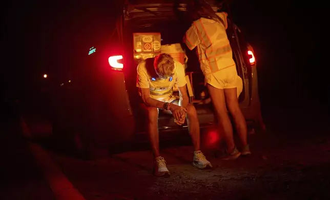 Danny Westergaard rests beside Jennifer Drain, his cousin and crew lead, during the second night of the Badwater 135 Ultramarathon, Tuesday, July 8, 2025, in Death Valley National Park, Calif. (AP Photo/John Locher)