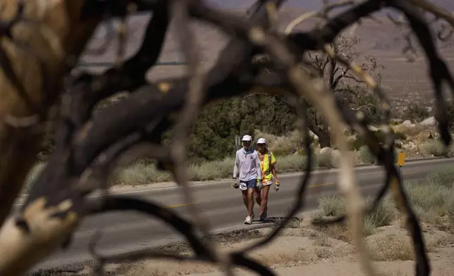 Danny Westergaard, left, competes during the Badwater 135 Ultramarathon beside Jennifer Drain, his cousin and crew lead, Wednesday, July 9, 2025, near Lone Pine, Calif. (AP Photo/John Locher)
