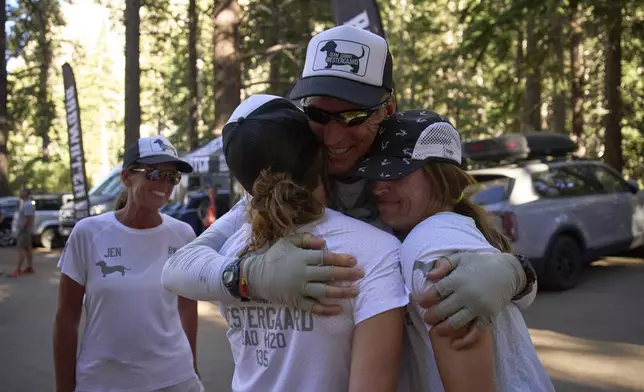 Danny Westergaard, second from right, embraces daughters Meagan Westergaard, right, and Madison Westergaard after finishing the Badwater 135 Ultramarathon, Wednesday, July 9, 2025, at Whitney Portal near Lone Pine, Calif. (AP Photo/John Locher)