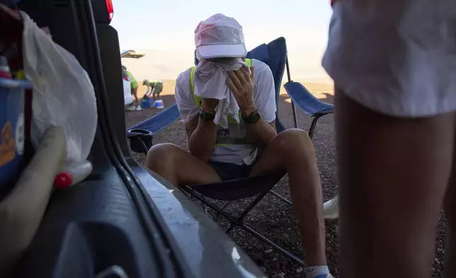 Danny Westergaard cools off in the shade while taking a short break during the Badwater 135 Ultramarathon, Tuesday, July 8, 2025, in Death Valley National Park, Calif. (AP Photo/John Locher)