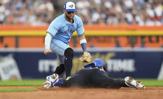 Detroit Tigers' Dillon Dingler, bottom, dives for second base against Toronto Blue Jays shortstop Bo Bichette, top, after hitting a double to score Wenceel Perez during the second inning of a baseball game Friday, July 25, 2025, in Detroit. (AP Photo/Ryan Sun)